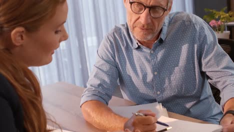 Businesspeople-discussing-over-document-with-digital-tablet-on-table