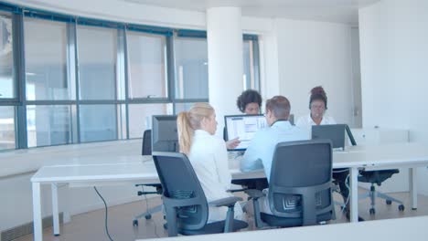 pasante preguntando al mentor sobre datos financieros en el monitor