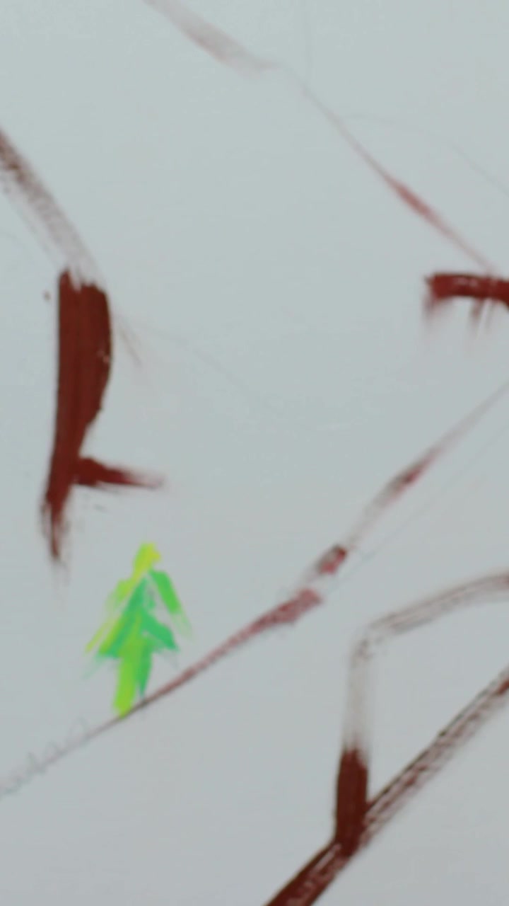 Video verticale: Mano con polsino blu che intinge il pennello, disegnando linee marroni e un albero verde su tela, con spazio per il testo.