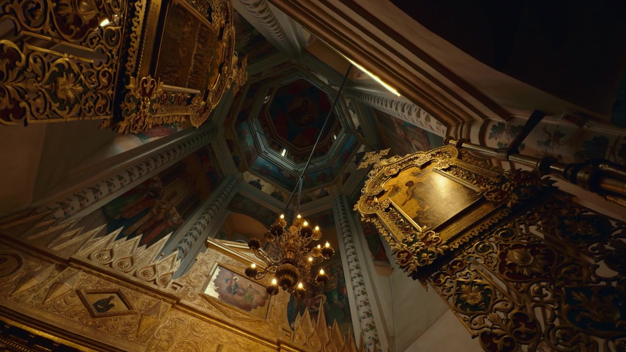 Soffitto e lampadario di una cattedrale russa ornata, guardando verso l'alto un soffitto di cattedrale riccamente decorato circondato da cornici dorate e opere d'arte religiose tradizionali