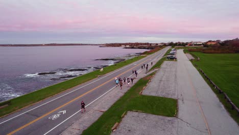 antena de corredores corriendo junto al océano al amanecer entrenando para una carrera de 10k