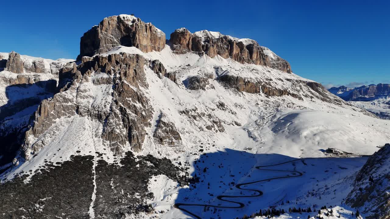 Outstanding rock formation in the Italian Dolomites covered with snow during winter season (drone footage)