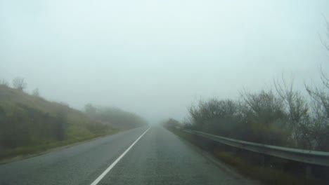 car travels in fog and rain