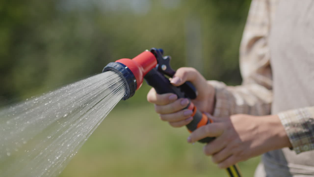 jardinero rocía agua de una manguera de jardín 2
