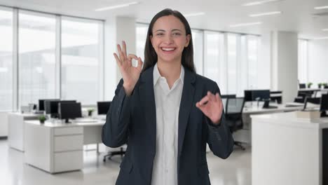 una mujer india feliz que muestra una señal de que está bien