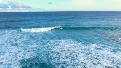 Toma-Aérea-De-Un-Surfista-Tallando-Olas-En-Un-Longboard-En-Hawaii