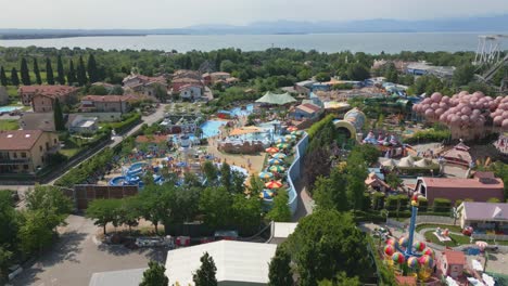 drone aerial tilt up reveals amusement park full of happy vacation tourists on holiday