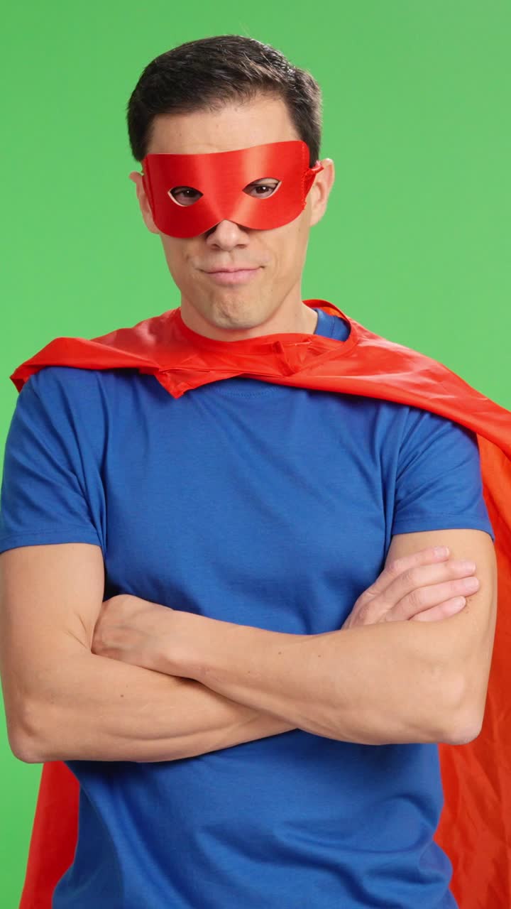 Superhero posing with crossed arms on green screen
