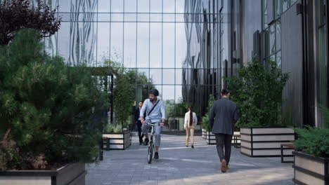 office manager riding bicycle in helmet at business district. city mobility.