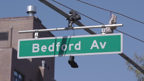 Sneakers-hanging-off-the-Bedford-Ave-Street-sign-in-Brooklyn,-New-York