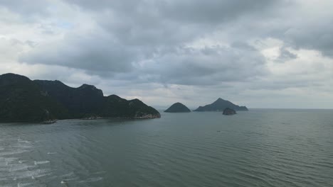 Sliding-to-the-right-revealing-the-ocean-and-islands-in-the-horizon,-gray-rain-clouds