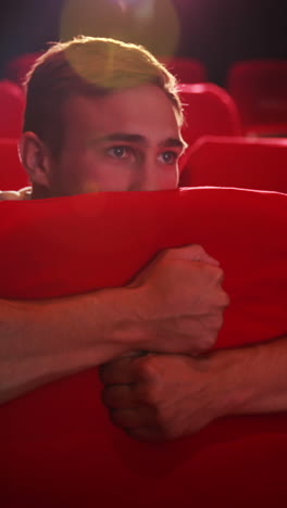 young man watching a scary film