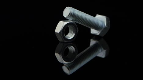 metal bolt and nut on reflective black surface