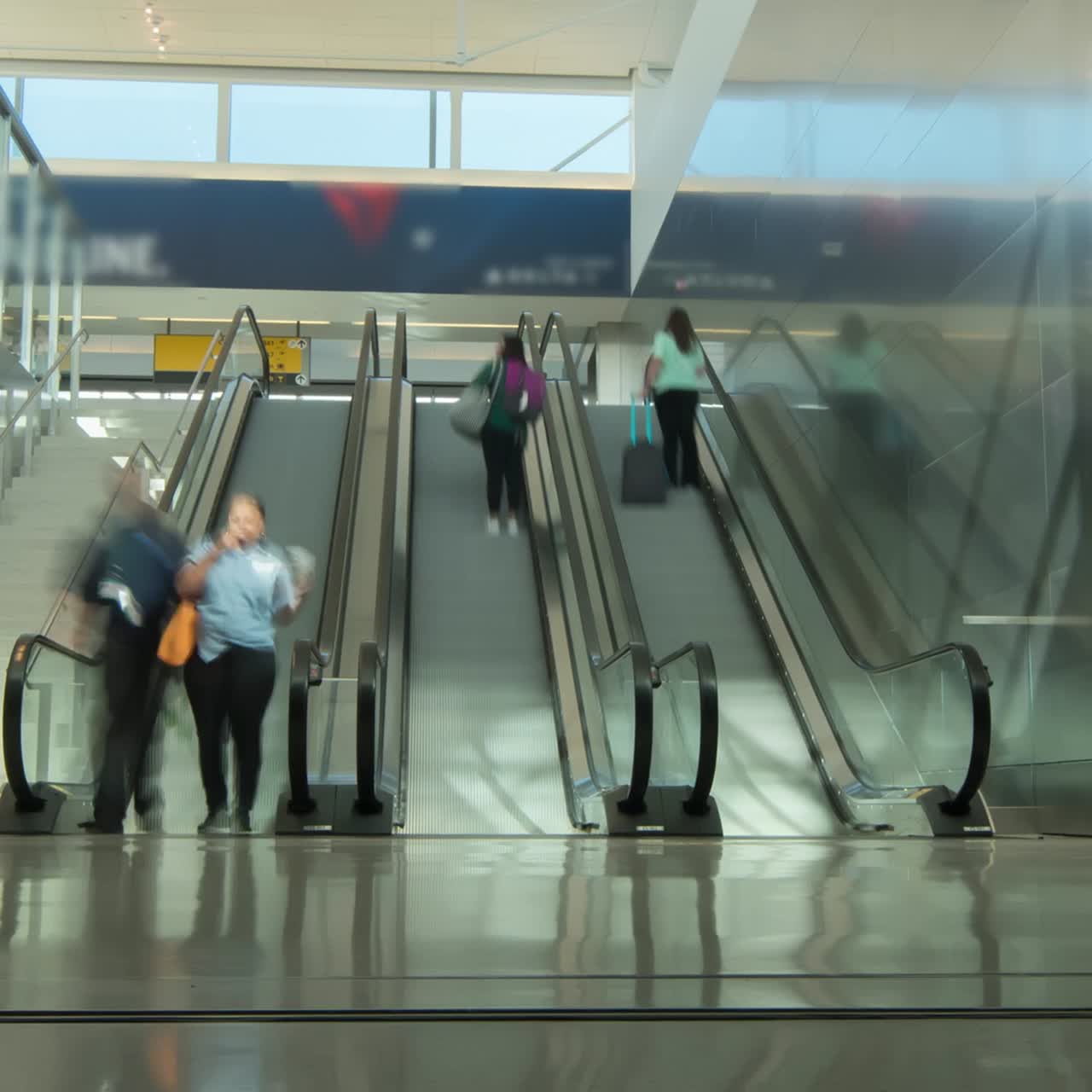 personas en una escalera mecánica del aeropuerto