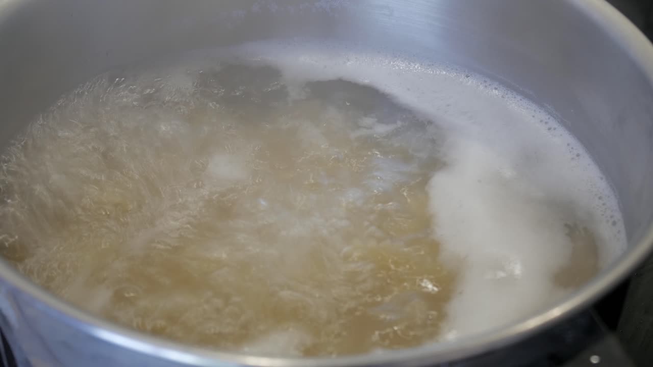 Close-up of pasta boiling in pot, showing cooking process and movement