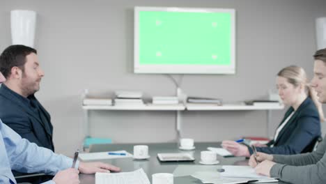 colleagues have a conversation at the meetingroom in front of a greenscreen