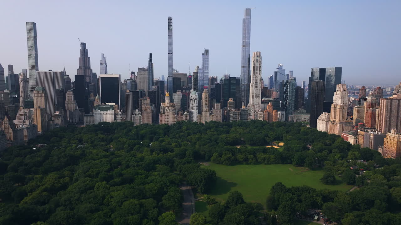 Panoramic drone shot over Central park with Midtown Manhattan highrise background