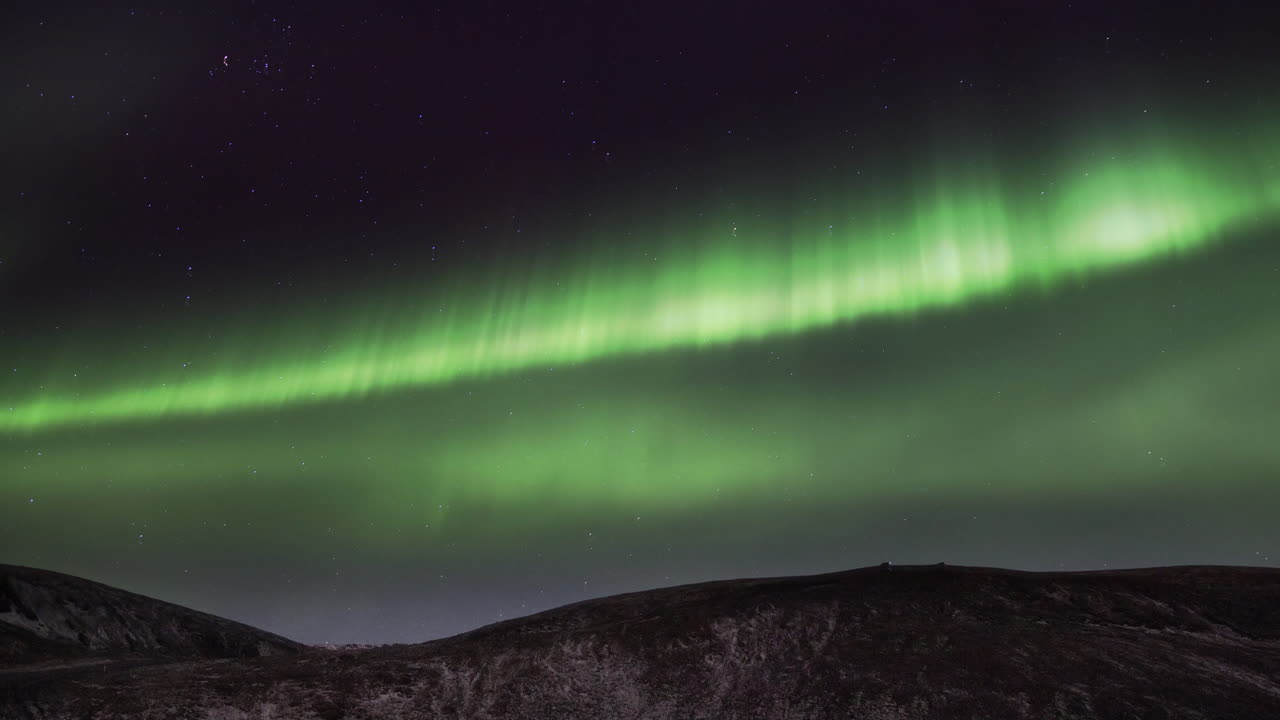 la aurora boreal brilla sobre las montañas en el cielo estrellado