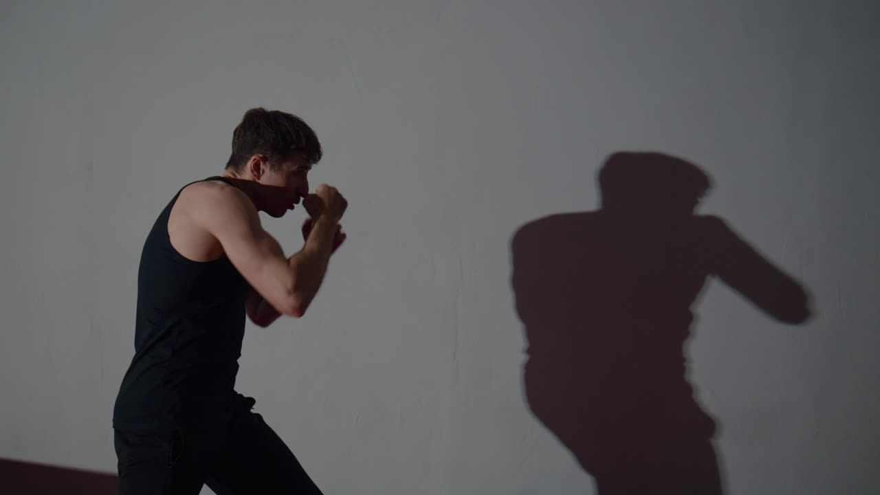 Man Shadow Boxing and Training Against a Wall