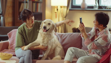 asian women taking pictures with dog at home