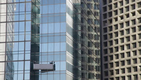 window cleaner at modern glass skyscrapers in hong kong central business district