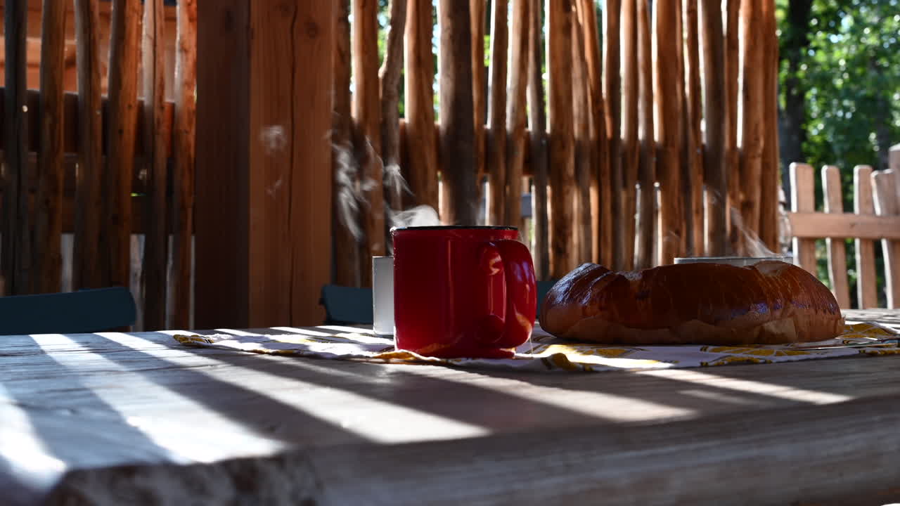 증발하는 물과 롤빵이 있는 뜨거운 차 한 잔, 측면 보기