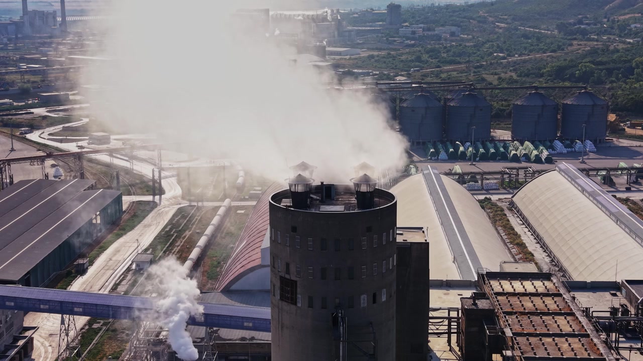 Fumo che sale dalle fabbriche in un'area industriale di giorno
