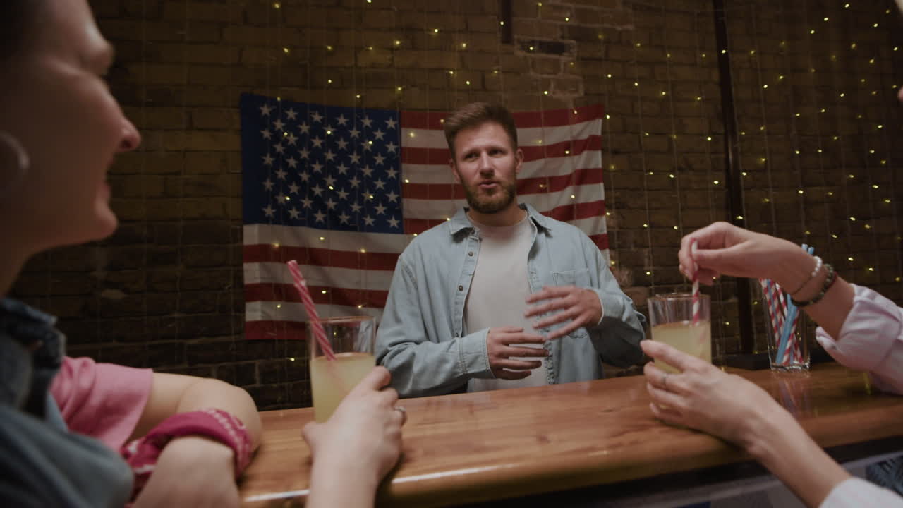 Friends enjoying drinks at a bar with an American flag