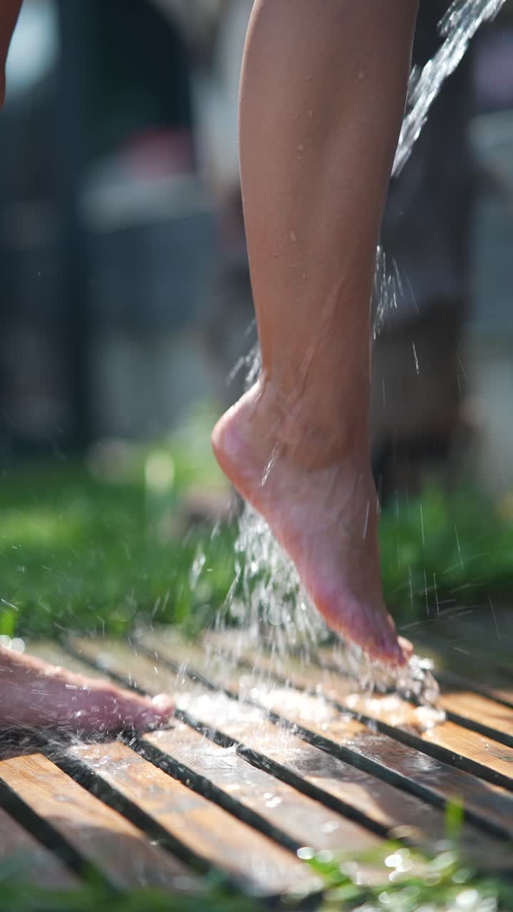 어린이의 발이 야외에서 물을 뿌리고 있습니다.