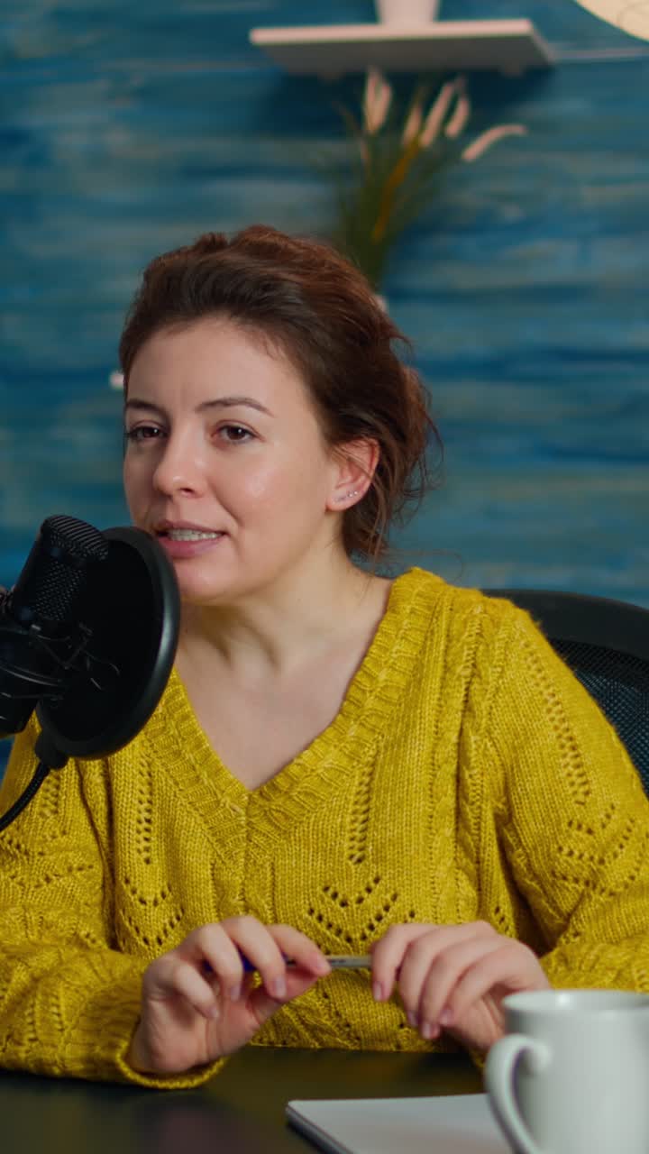Video verticale: Influencer che produce un vlog con attrezzatura professionale in uno studio casalingo