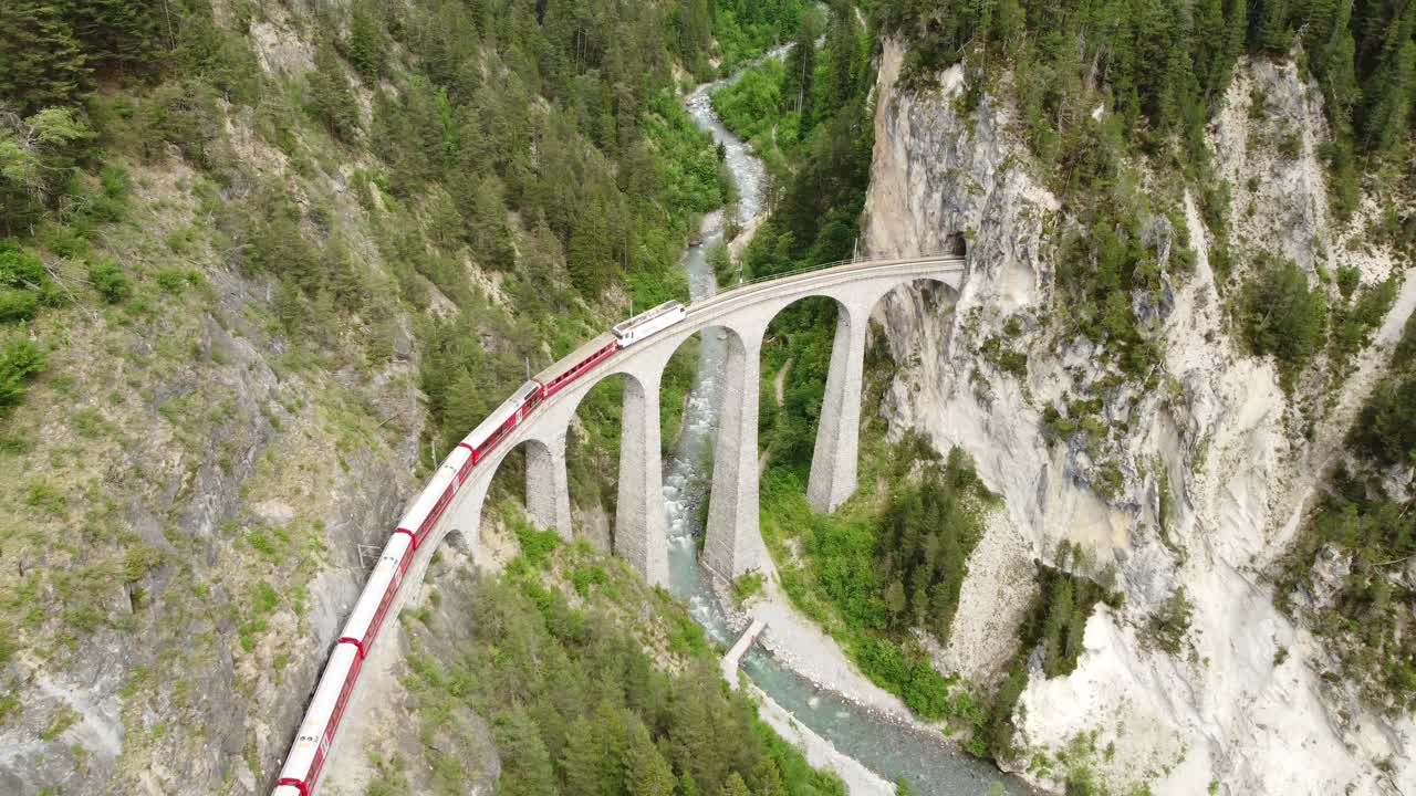 las imágenes hipnotizantes de 4k capturan el majestuoso cruce expreso del glaciar, el viaducto landwasser, un puente arqueado de piedra caliza diseñado por alexander acatos.