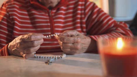 4K-video-of-an-elderly-women-holding-the-holy-rosary-and-praying-next-to-the-Holy-Bible