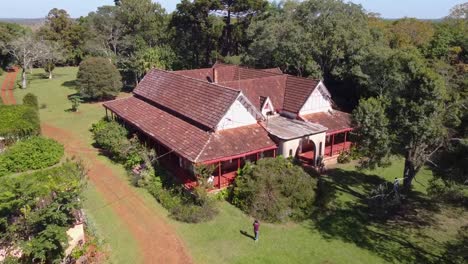 Vuelo-De-Drones-En-Un-Edificio-Antiguo-Con-Tejas-Rojas-Y-Un-Hombre-Tomando-Fotos