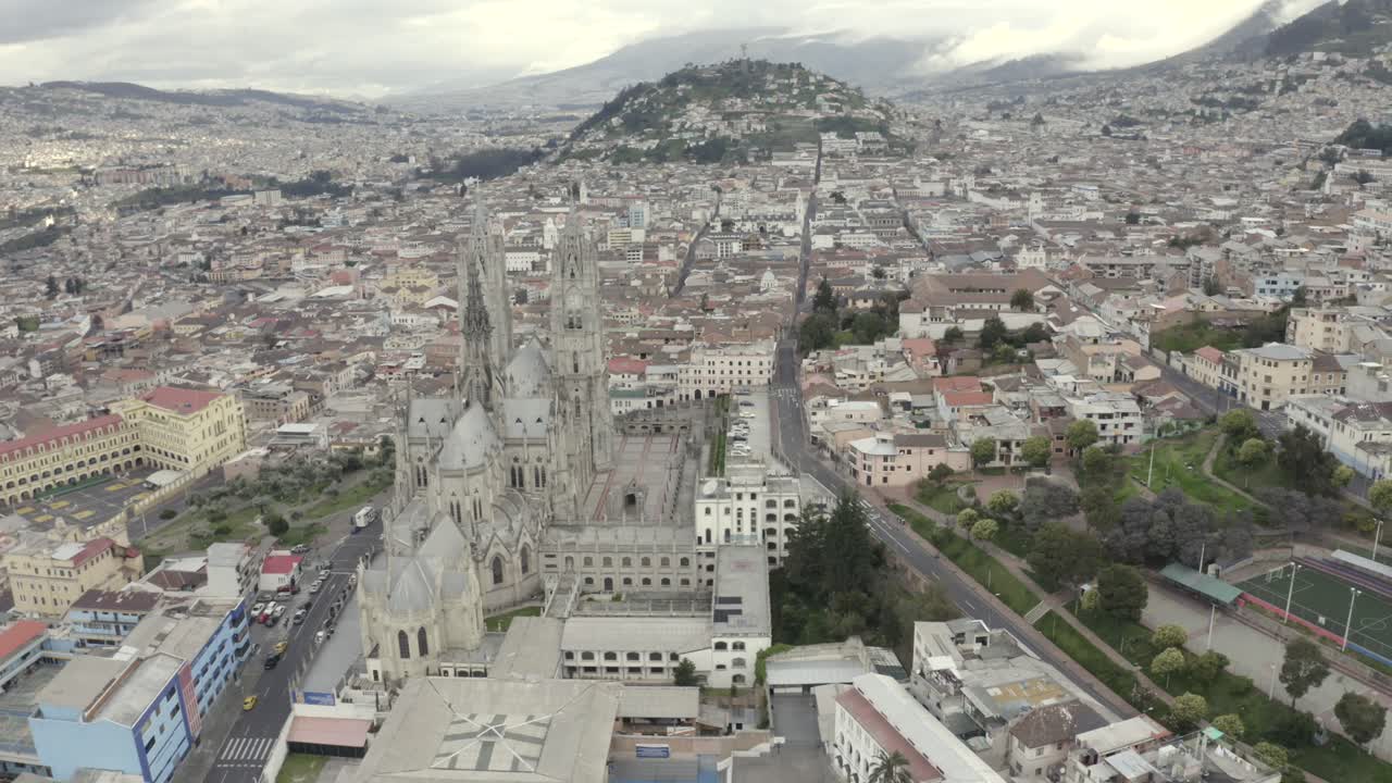 Drone shot of La Basilica del Voto Nacional located in the historic center of Quito, Ecuador. Virgin of Legarda over the Panecillo during quarantine. Houses and empty streets.