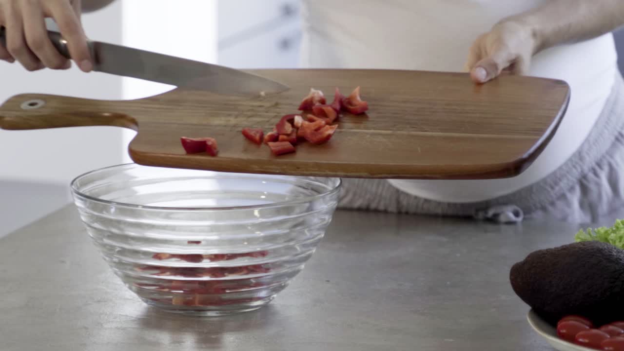 disparo en primer plano de una mujer embarazada poniendo pimienta en un cuenco