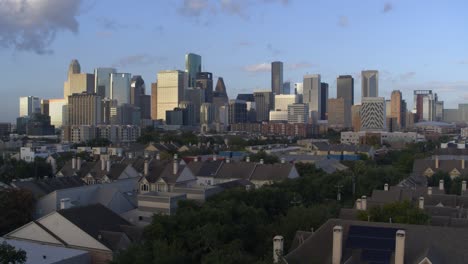 establishing aerial shot of homes and downtown houston, texas in the background