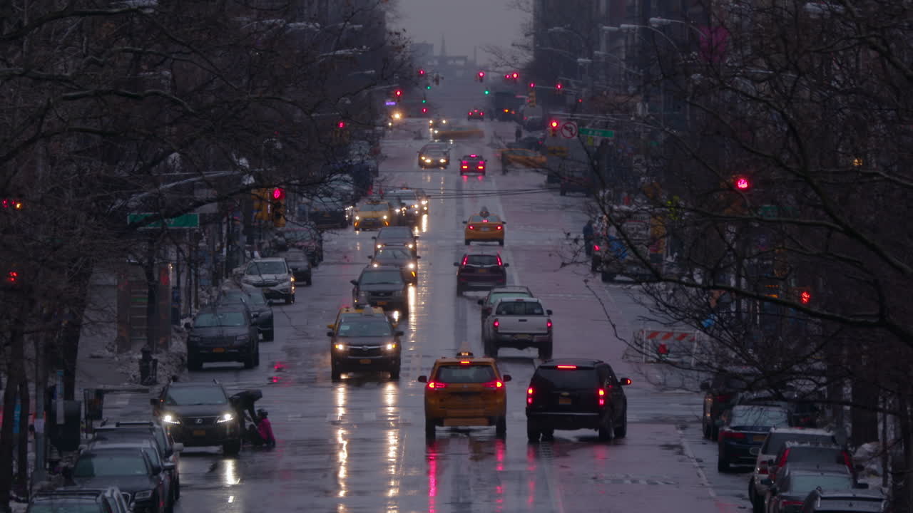 눈이 내리는 겨울에 교통 체증이 있는 젖은 뉴욕 맨하탄 메인 스트리트의 슬로우모션