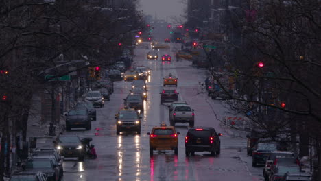 Cámara-Lenta-De-Una-Calle-Principal-Húmeda-De-Manhattan-De-Nueva-York-Con-Tráfico,-En-Invierno-Con-Nieve