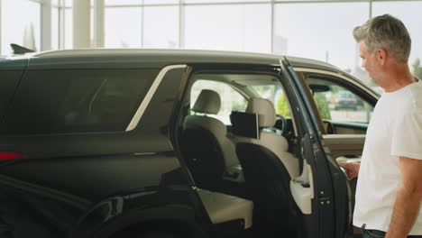 customer looking at interior of a black suv at a dealership