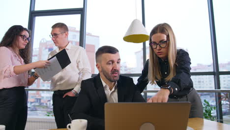 brainstorming and decision-making in modern office. team members split into pairs to discuss and solve business issues. panorama of the city at backdrop.