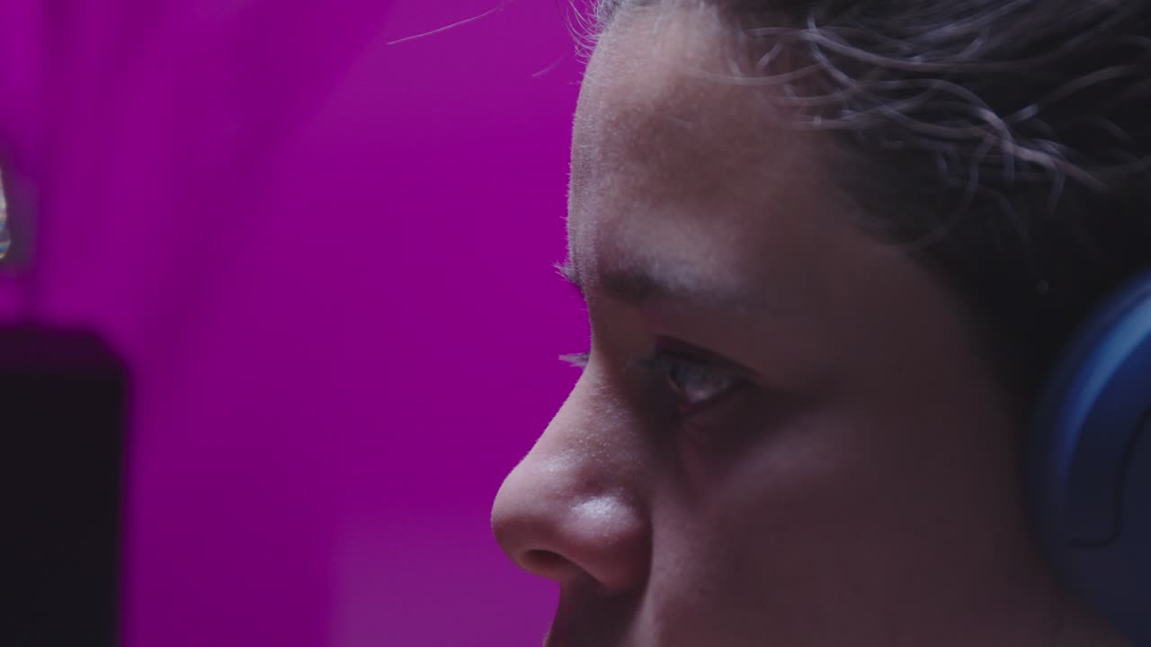 A cinematic sequence of a young female gamer concentrating intensely on a screen, pausing for a quick water break. Ungraded LOG footage for a professional, modern look