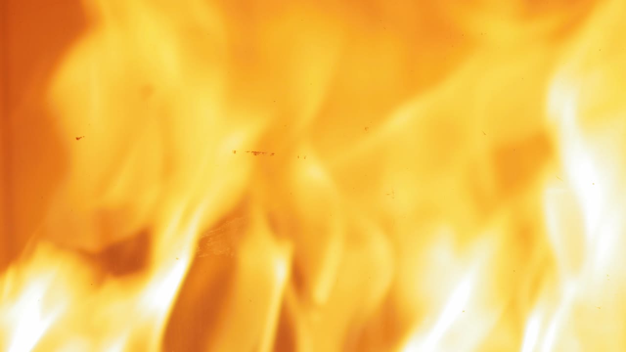 Un ceppo ardente crolla tra le fiamme nel camino.