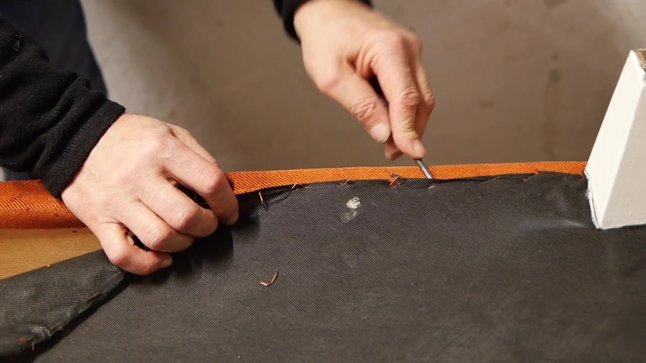 Tapicero quitando grapas de la tela de una silla