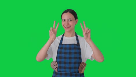 ama de casa india feliz mostrando el signo de la victoria pantalla verde