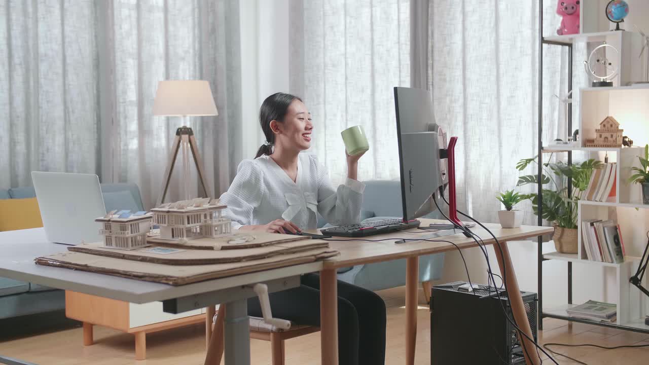 집에서 데스크에서 일하면서 커피를 마시는 하우스 모델과 함께 아시아 여성 엔지니어