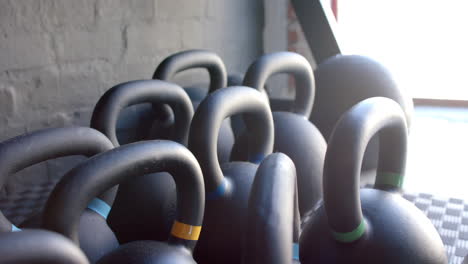 Kettlebells-In-Verschiedenen-Größen-Ruhen-Auf-Dem-Boden-Des-Fitnessstudios,-Bereit-Zum-Einsatz