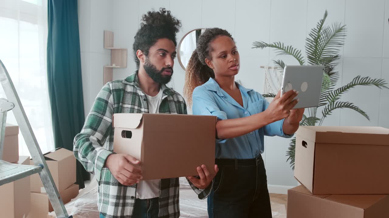 mujer y hombre multinacionales trabajan como diseñadores de interiores de pie en una habitación con cajas