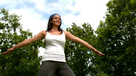 una morena bonita haciendo yoga en el parque.