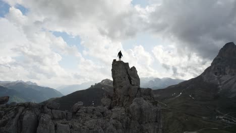 orbit drone shot of a person on top of the mountain at passo sella in val gardena italy