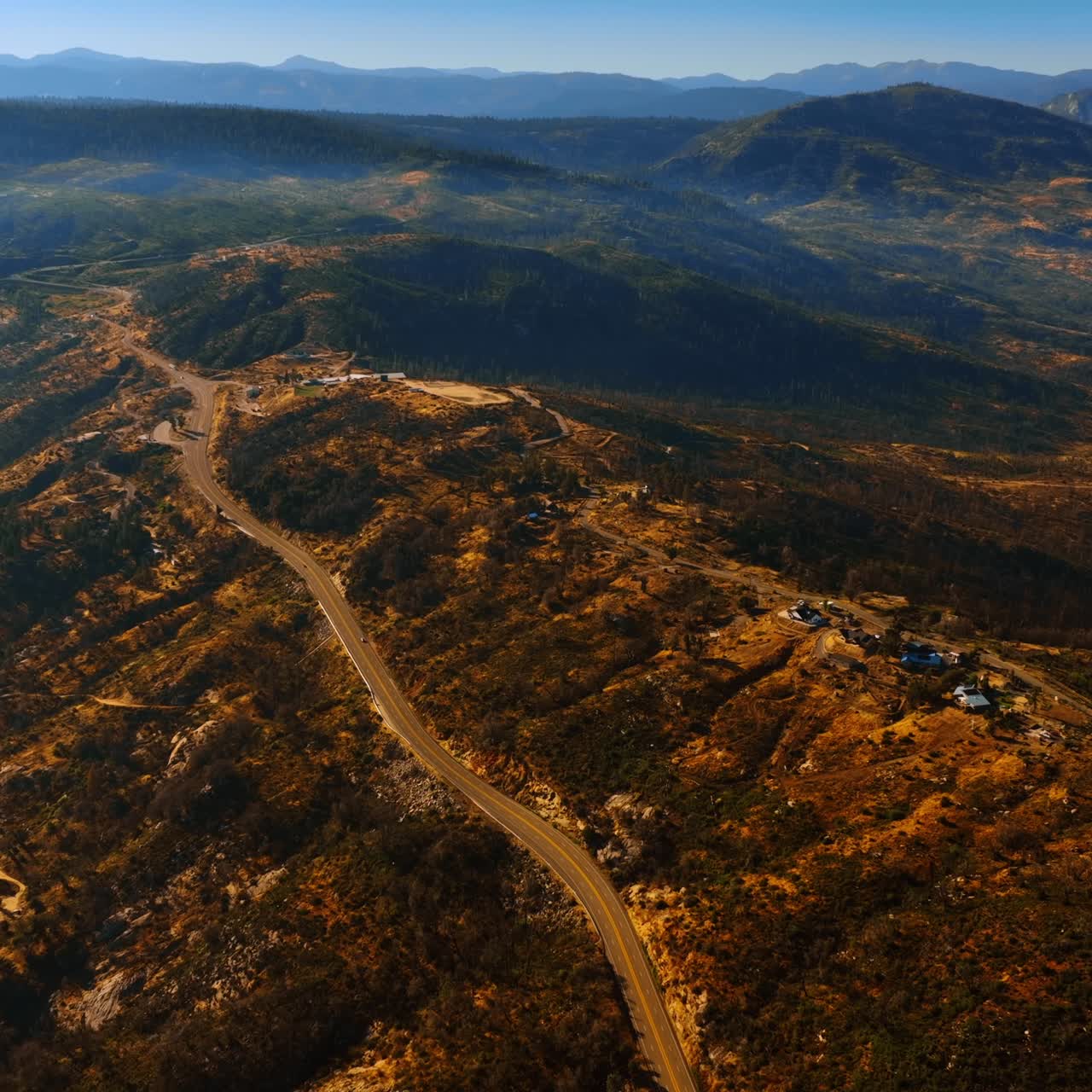 Few houses located on the bare rocks at Sierra National Forest, USA. Amazing rocky landscape at backdrop. Aerial perspective